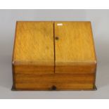 An Edwardian oak fitted stationary box with glass inkwells.