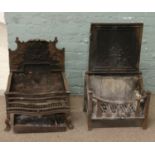 Two cast iron fire baskets with decorative back plates.