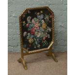 A gilt folding fire screen with floral embroidered panel.