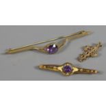 Three pieces of 9ct gold and amethyst jewellery two bar brooches and a cross shaped pendant,