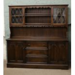 An oak dresser with leaded glass top and linen fold doors.