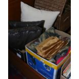 A box of assorted textiles and four decorative cushions.