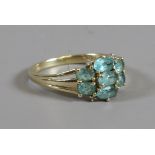 A 9ct gold dress ring set with seven green ovoid faceted gems and four diamonds, size P.