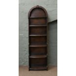 A mahogany open dome top waterfall bookcase of slender proportions.