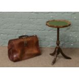 A vintage leather Gladstone bag, along with a tripod wine table with leather top.