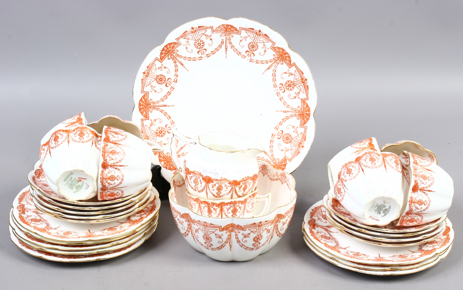 A Victorian Foley china part tea service printed with red borders. 9 cups and saucers.