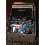A box of vinyl records and singles including rock, easy listening and compilations.