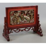 A Chinese red lacquer and carved wood table screen with gilt decoration and a shell fragment