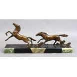 An Art Deco bronze of galloping horses raised on a slate and onyx plinth.