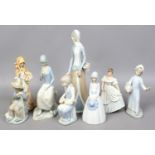 A Wedgwood figure of a lady along with seven other ceramic figures.