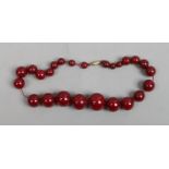 A string of Art Deco cherry amber coloured Bakelite beads of graduated spherical form, 70g.