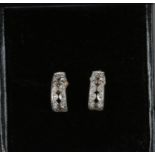 A pair of 9ct gold diamond set pierced scroll shaped earrings.