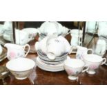 A Susie Cooper china part tea service decorated with roses including six trios, milk jug,