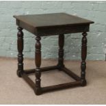 A carved oak occasional table raised on turned supports.