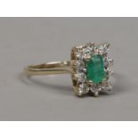 A 9ct gold emerald and diamond cluster ring with rectangular table size 5.