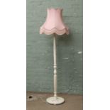 A cream painted fluted column standard lamp with pink shade.