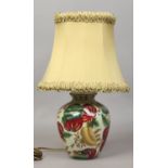 A green floral based pottery tablelamp with oval green shade.