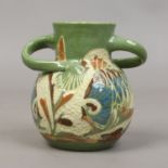 A Brannam art pottery vase with looped handles, green glazed and with incised fish decoration.