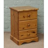 A pine three drawer bedside chest.