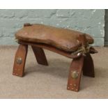 A leather camel saddle stool.