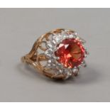 A 9ct gold dress ring with wirework shank set with a large orange stone surrounded by white paste