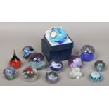 Thirteen Caithness glass paperweights including a boxed example inset with a clock.