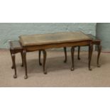 A carved mahogany glass top coffee table with two inbuilt occasional tables stored below.