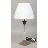 A frosted glass column tablelamp with pleated grey silk shade.