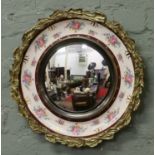 A round Burleigh ware wall mirror with gilt border and floral pattern.