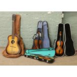 Three cased violins along with a vintage Egmond acoustic guitar in canvas.