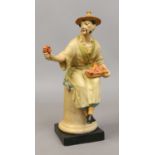 A Royal Worcester figure 'le panier' modelled by A. Azor and decorated in cellulose glazes.