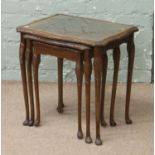 A nest of three mahogany and glass top tables.