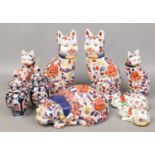 A collection of large oriental porcelain Imari cats and a pair of similar fluted urns.