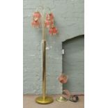 A brass five branch standard lamp with floral shaped shades along with a matching tablelamp.