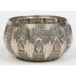 A 19th century Indian white metal bowl decorated with repousse panels containing deities and