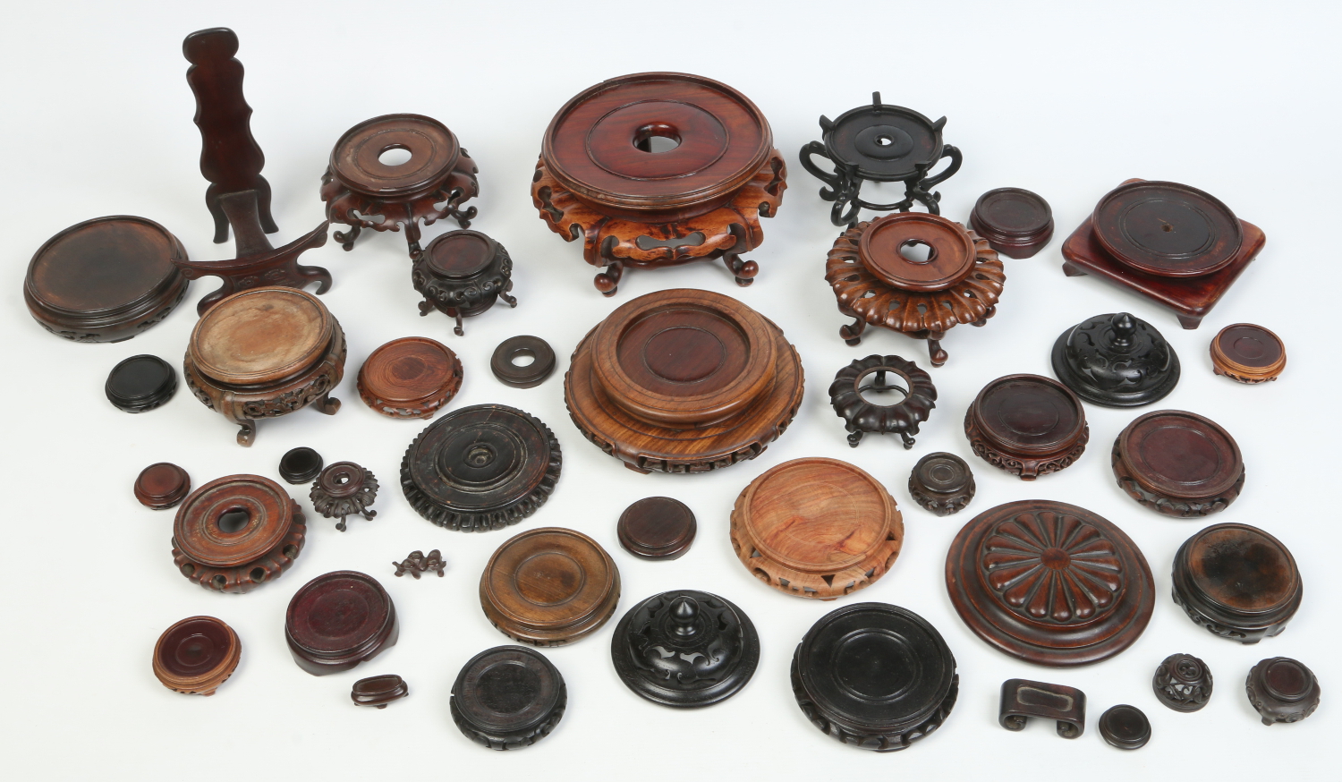 A collection of carved hardwood Japanese and Chinese stands and covers, 19th and 20th century.