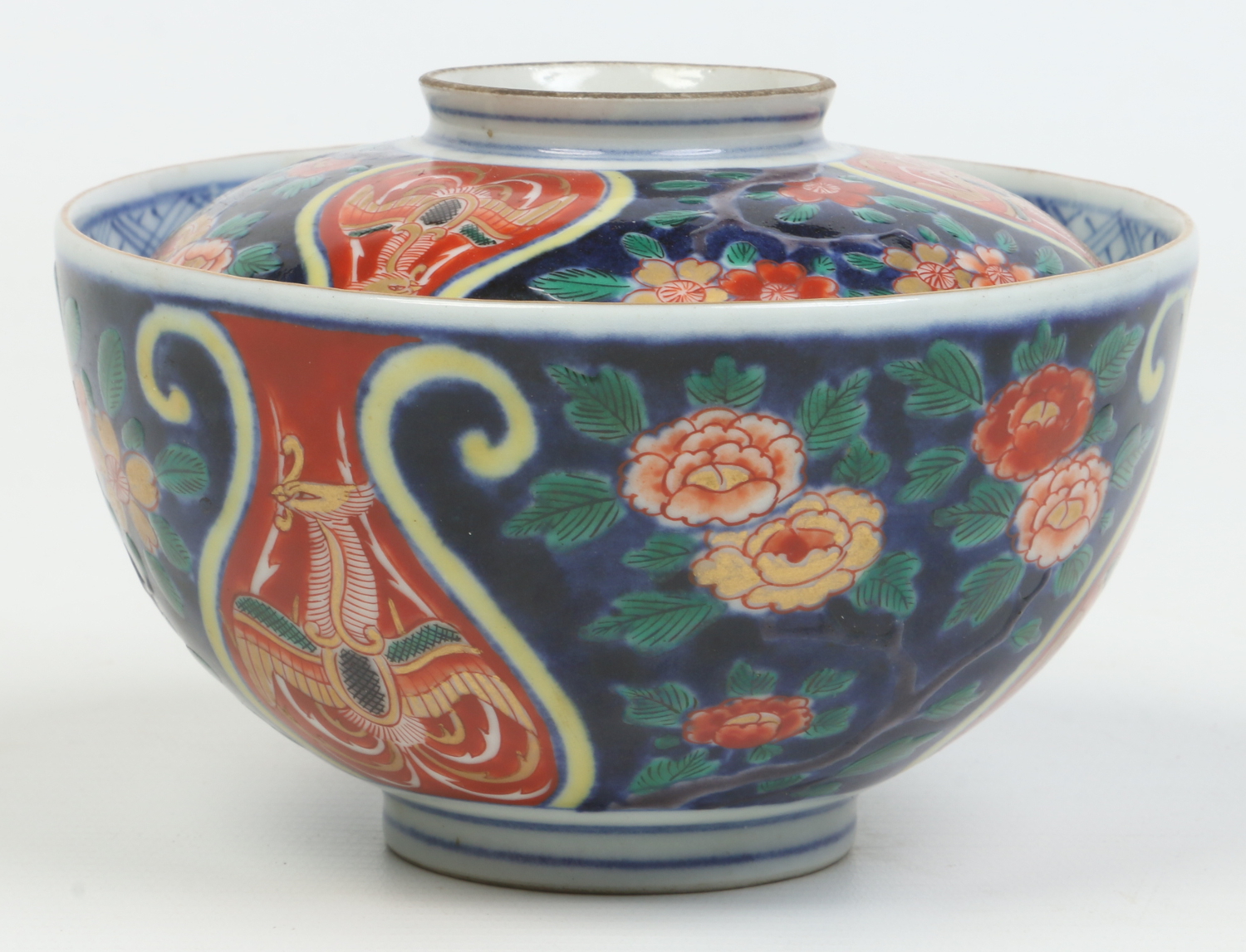 A Japanese Meiji period Imari bowl and cover painted with phoenix on red ground lyre shaped panels