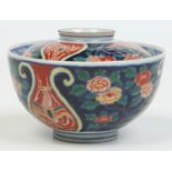A Japanese Meiji period Imari bowl and cover painted with phoenix on red ground lyre shaped panels