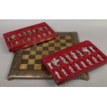 A boxed brassed novelty chess board with a set of crusade themed pieces,