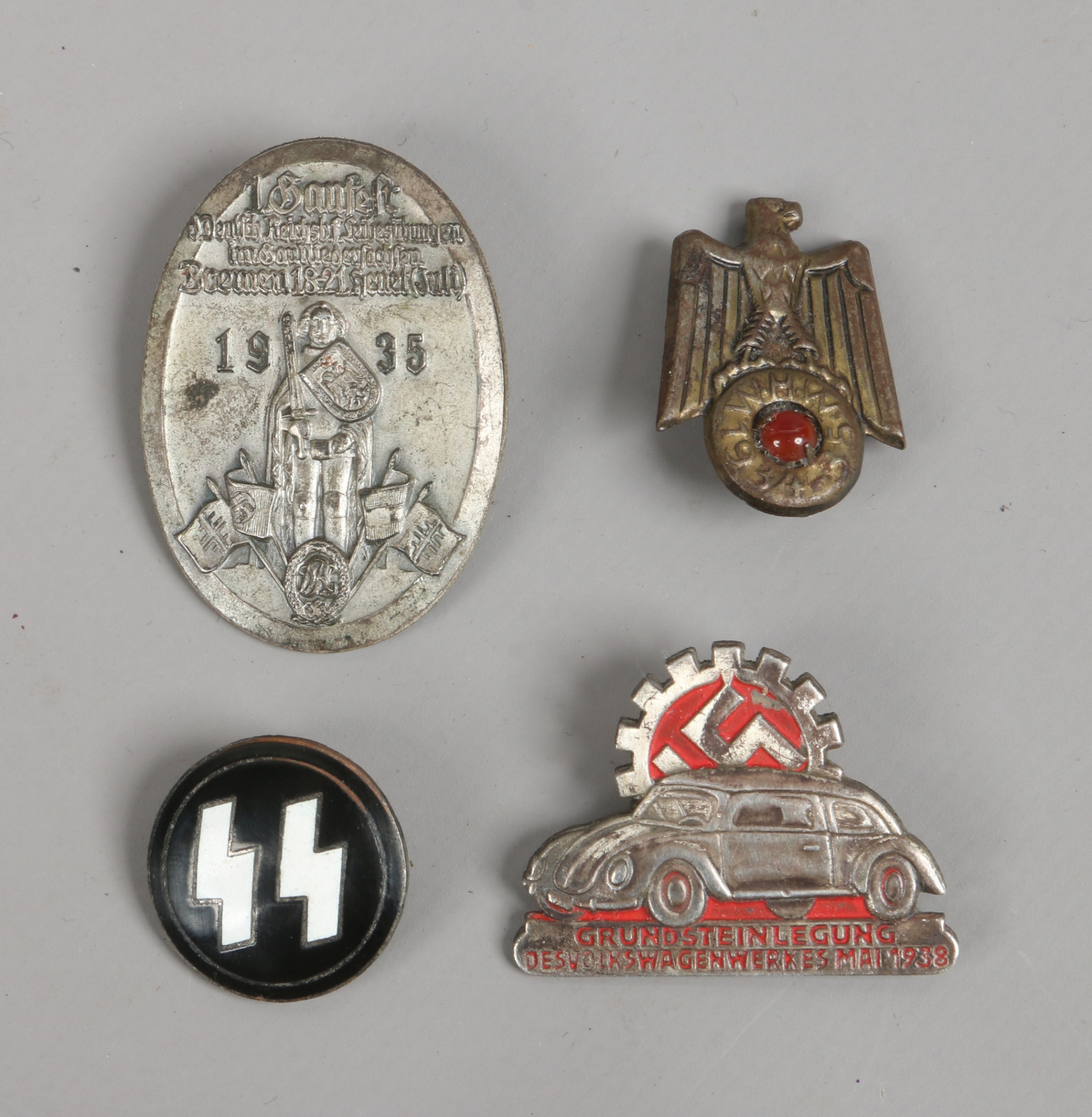 Four German World War II badges; Volkswagen 1938 and SS etc.