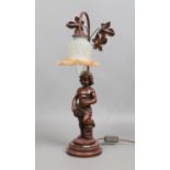 A bronzed figural tablelamp formed as a putti.