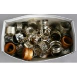 A box of silver plated and carved wooden serviette rings.