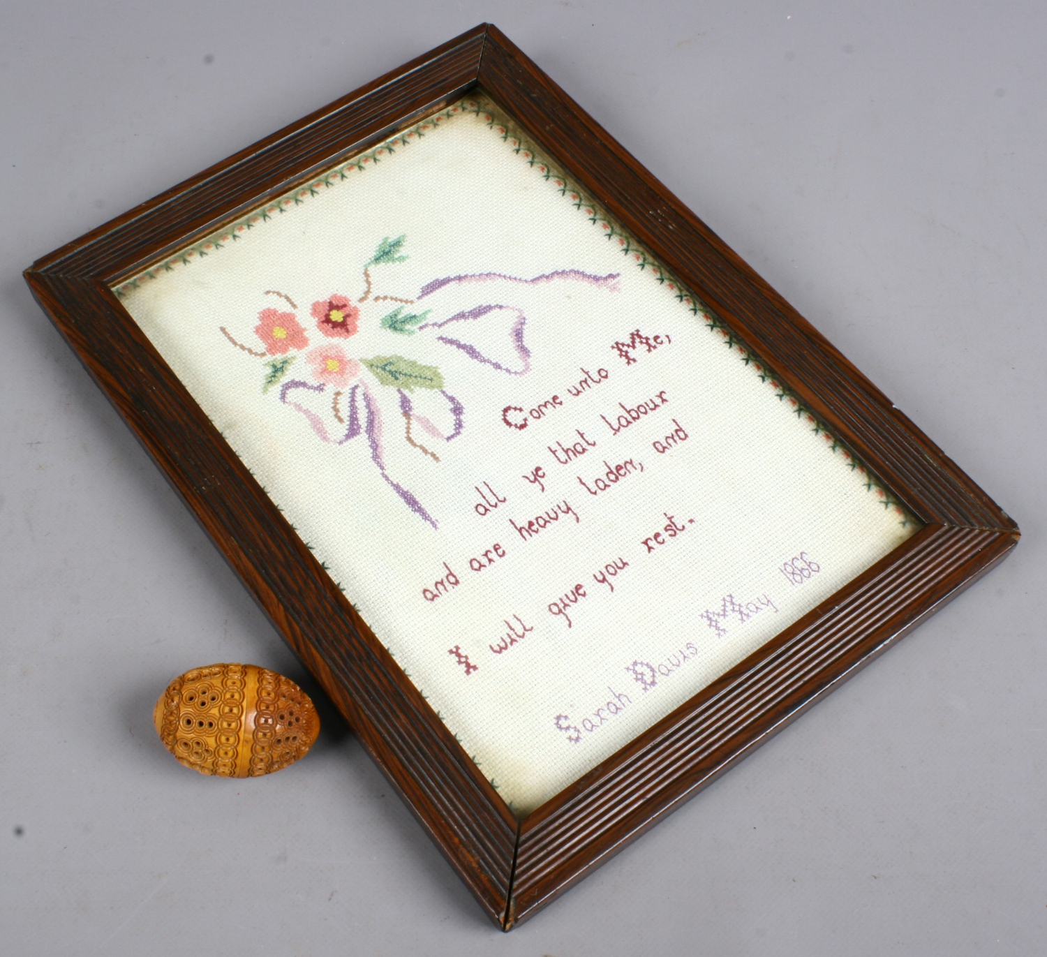 A framed Victorian sampler by Sarah Davis, dated May 1866 along with a carved and pierced treen egg.