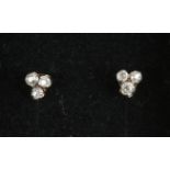 A pair of 9ct gold ear studs, each trefoil set with three diamonds.