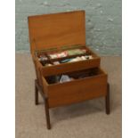 A light oak cantilever sewing box and contents of sewing equipment.