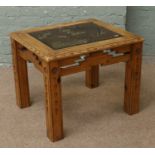 A carved hardwood smoked glass top coffee table.