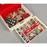 A cream jewellery box and contents of mixed costume jewellery including two pheasants foot brooches,