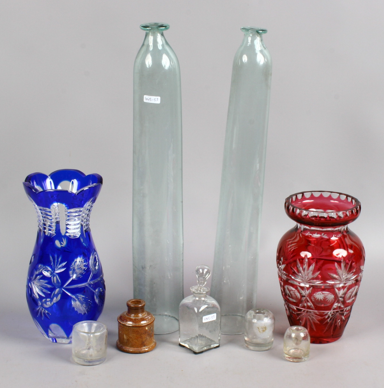 A collection of glasswares to include hand blown cucumber straighteners, coloured cut glass vases,