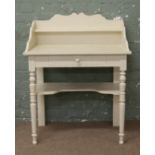 A white painted washstand on turned supports.