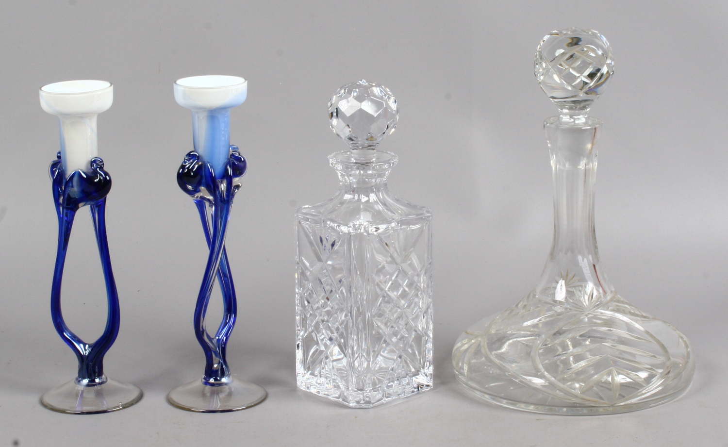 Two cut glass decanters along with two art glass candlesticks.